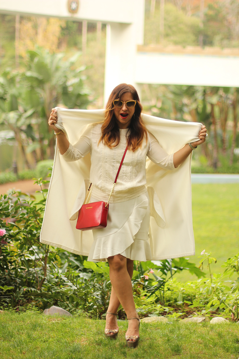 Rossana Vanoni fashion blogger at Lake Shrine wears white coat, blouse and skirt